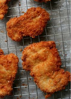 four fried chicken patties on a cooling rack