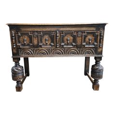 an old wooden table with ornate carvings on the top and bottom, against a white background