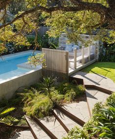 an above ground swimming pool surrounded by trees and bushes with stairs leading up to it