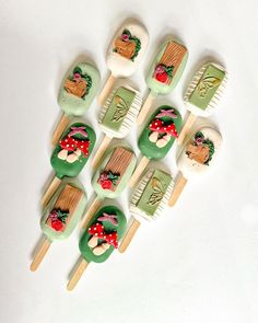 six toothbrushes with green and red designs are arranged on top of each other