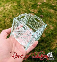 a hand holding a small glass basket in it's left hand on the grass