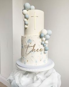 a white cake with blue decorations and a cross on top