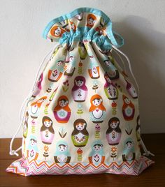 a drawstring bag with colorful owls on it sitting on top of a wooden table