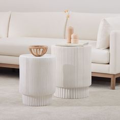 two white vases sitting next to each other on top of a carpeted floor