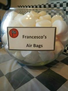 a glass bowl filled with white marshmallows on top of a checkered table cloth