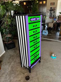 a purple and green dresser sitting on top of a carpeted floor