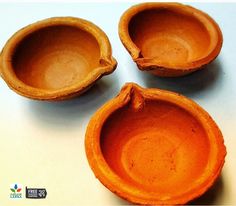 three orange clay bowls sitting on top of a table