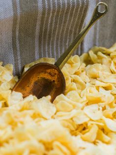 a bowl filled with pasta and a wooden spoon