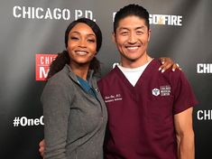 a man and woman standing next to each other in front of a chicago fire sign