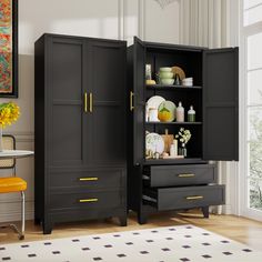 a black cabinet with yellow handles and drawers in a room next to a chair, table and window