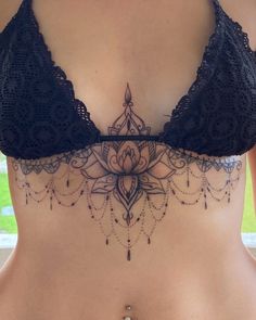 a woman's stomach with an intricate tattoo on it