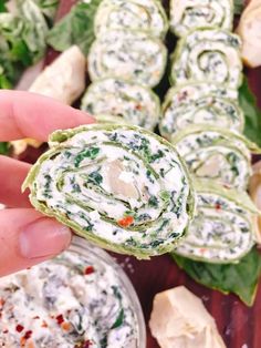 spinach rolls with white sauce being held up