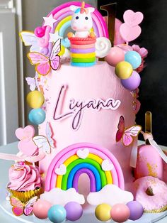 a birthday cake decorated with pink icing and lots of colorful decorations on top of it