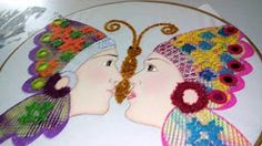 two women wearing headdresses are kissing each other on a plate with flowers