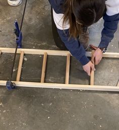 a woman is working on an unfinished piece of wood