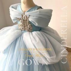 a dress made out of blue tulle with a large brooch on the back