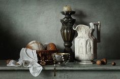 a table topped with vases and other items on top of a wooden shelf in front of a gray wall