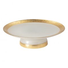 a white and gold plate sitting on top of a table