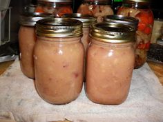 four jars filled with food sitting on top of a table