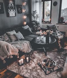 a living room filled with lots of furniture and candles on the table in front of it