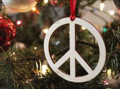 a peace sign ornament hanging from a christmas tree