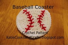 a crocheted baseball ball with red stitches on it sitting on a wooden floor