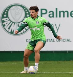 a soccer player in action on the field during a game with green and white uniforms