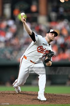 a baseball player throwing a ball in the middle of a pitch during a game stock photo