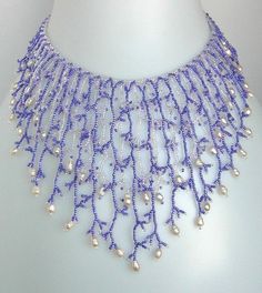 a blue and white beaded necklace on a mannequin neckpiece with pearls