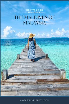 a woman walking across a wooden bridge over water with the words how to go to the maldives of malaysia