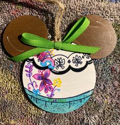 a mickey mouse ornament with a green bow