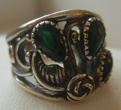 "Sterling silver and green abalone ring. Three teardrops are set in a cut-out flower and feather design with pebbled tendrils on the side and a split band that joins to a solid back band. The green abalone is a deep emerald color. A beautiful and unique ring that can be worn both ways: teardrops beneath the center rosebud or teardrops at the top with the rosebud beneath. The ring is a handmade Southwestern design by Wheeler South Dakota, making jewelry since 1946. The hallmarks are difficult to Bohemian Silver Turquoise Teardrop Ring, Bohemian Teardrop Turquoise Ring In Silver, Bohemian Silver Teardrop Turquoise Ring, Antique Pear-shaped Silver Jewelry, Silver Teardrop Bohemian Rings, Silver Art Deco Jewelry With Inlay, Adjustable Teardrop Vintage Rings, Unique Silver Pear-shaped Rings, Adjustable Vintage Teardrop Rings