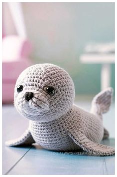 a crocheted stuffed seal is sitting on the floor