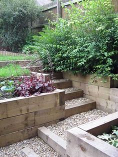 a garden with wooden steps and plants growing in the planter boxes on each side