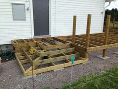 a house that is being built with some wood on the front porch and side yard