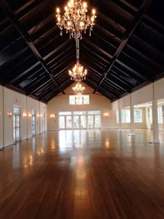 an empty ballroom with chandeliers and windows