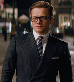 a man in a suit and tie standing on the street