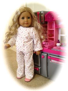 a doll is standing in front of a toy kitchen