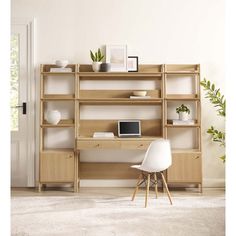 a computer desk sitting on top of a wooden shelf next to a white chair and potted plant