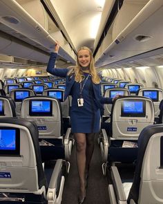 a woman standing on an airplane with her arms in the air