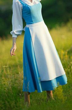 a woman in a blue and white dress is posing for the camera with her hand on her head