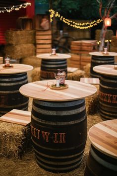 several wooden barrels sitting on top of hay in a room filled with lights and string lights