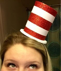 a woman wearing a red and white cat in the hat on top of her head