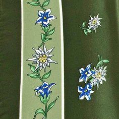 a green jacket with blue and white flowers on the side, along with two matching ties