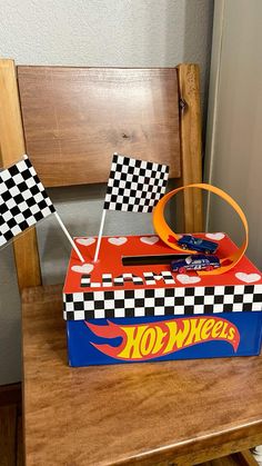 a hot wheels birthday cake sitting on top of a wooden table next to a chair