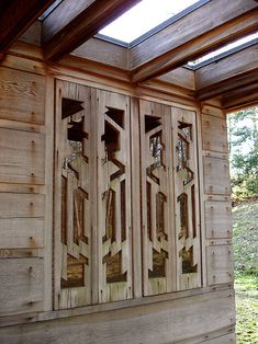 an open wooden door on the side of a building with skylights in the background