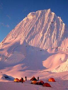 several tents pitched up in the snow with a mountain in the backgroung