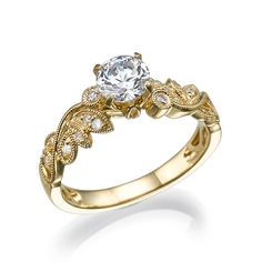 an engagement ring with a diamond in the center and leaves on the band, set against a white background