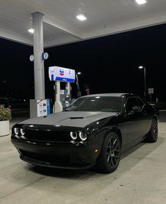 a black car is parked at a gas station