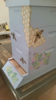 the beehive has been painted with flowers and bees on it's sides